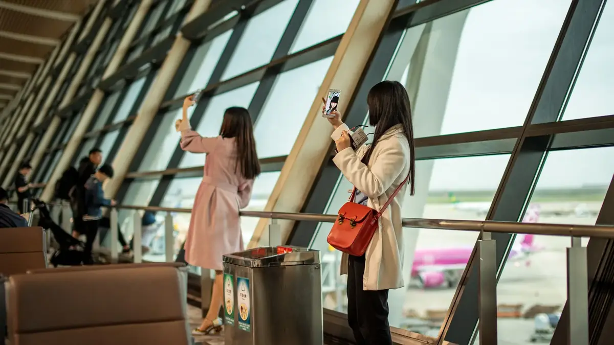 空港でスマホを見る旅行者